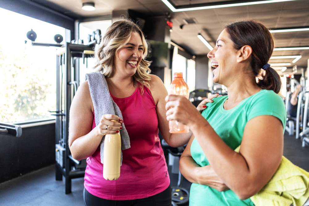 Abnehmen Fitness Zwei Frauen lachen sich an