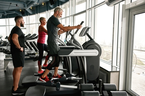 Couple,Of,Attractive,And,Fit,Retire,Woman,And,Man,Excercising Mann und Frau stehen auf Crosstrainern